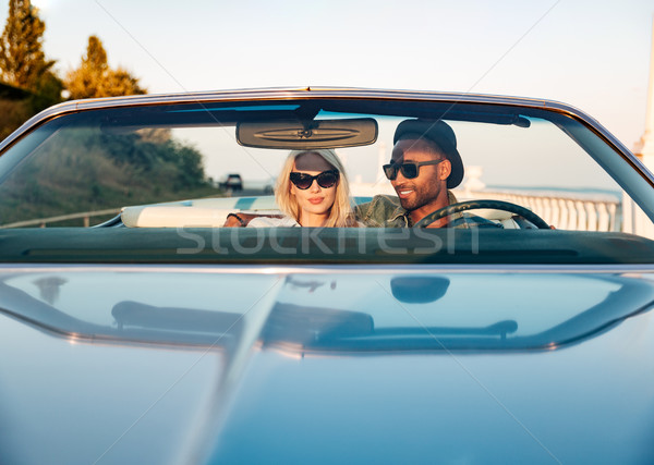Beautiful young couple sitting and driving cabriolet Stock photo © deandrobot