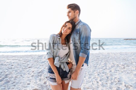 Beautiful couple holding hands and walking at the beach Stock photo © deandrobot