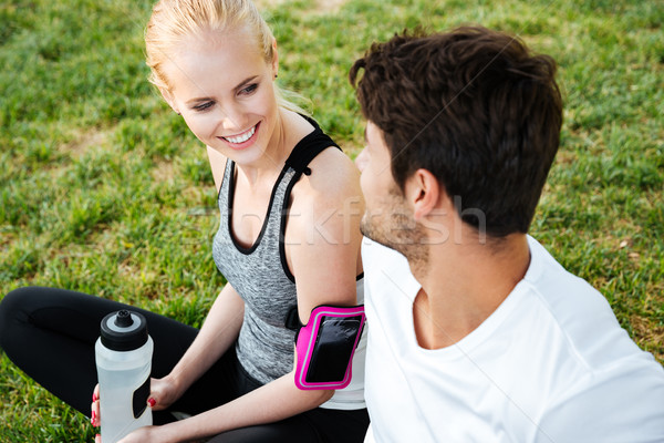 Young couple resting after training and drinking water in park Stock photo © deandrobot