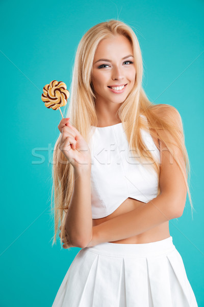 Smiling charming woman holding lollipop and looking at camera Stock photo © deandrobot