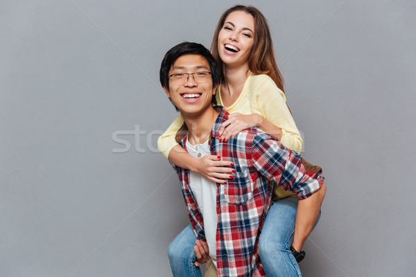 Portret tineri cuplu piggyback izolat Imagine de stoc © deandrobot