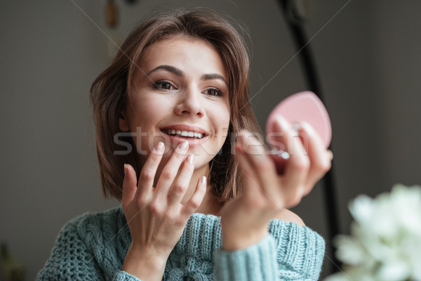 Cute pretty lady sitting in cafe and looking at mirror. Stock photo © deandrobot