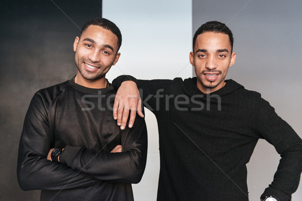 Two happy african american young men standing with arms crossed Stock photo © deandrobot