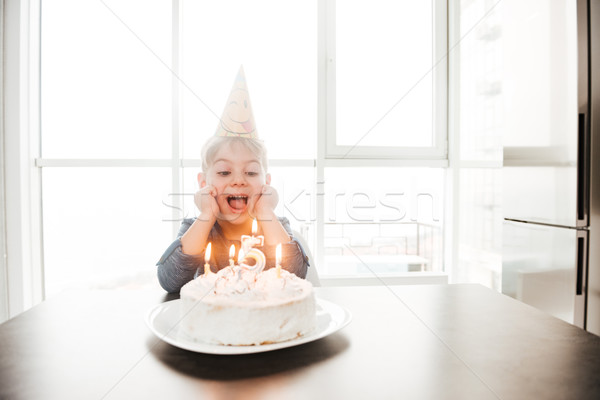 Birthday boy near cake while smiling. Stock photo © deandrobot