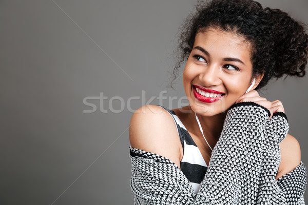 Smiling pretty woman listening to music with earphones Stock photo © deandrobot