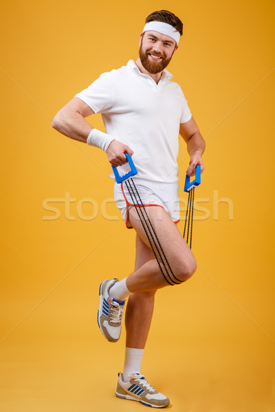 Portrait of a sporty man exercising with rubber expander Stock photo © deandrobot