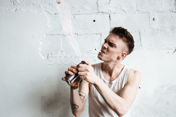красивый мужчина Постоянный полу газ спрей сигарету Сток-фото © deandrobot
