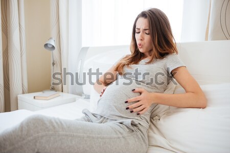 Mosolyog terhes nő tart fejhallgató pocak néz Stock fotó © deandrobot