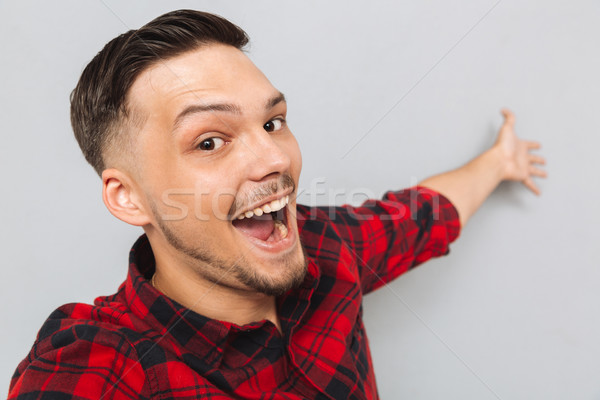 Happy  man standing sideways and posing in studio Stock photo © deandrobot