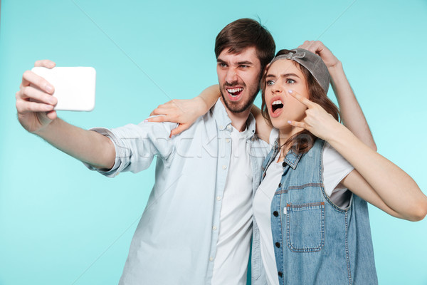 Emotional brother and sister make selfie by mobile phone Stock photo © deandrobot