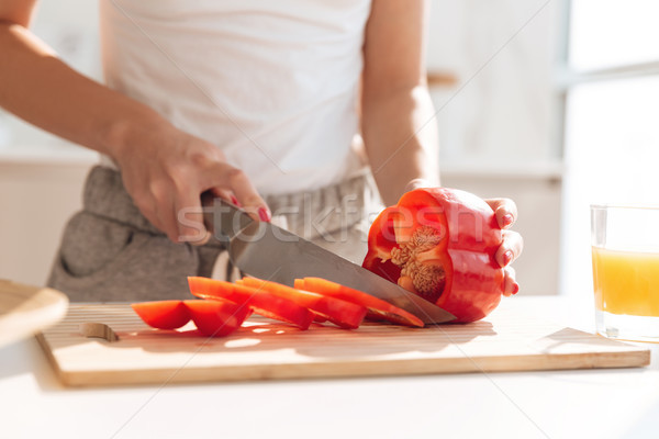 Close up portrait of young woman slicing red capsicum Stock photo © deandrobot