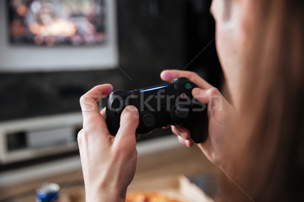 Young man gamer sitting at home indoors and play games Stock photo © deandrobot