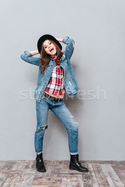 Smiling pretty woman in hat posing with mouth open Stock photo © deandrobot