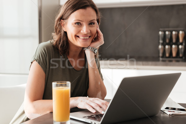 Happy casual woman sitting by the table with juice Stock photo © deandrobot