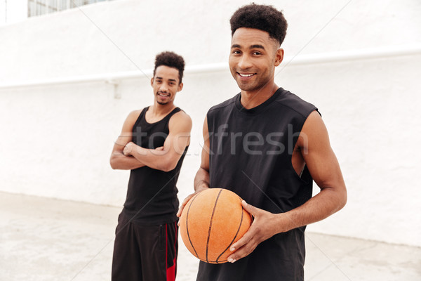 Happy young african sports men with basketball Stock photo © deandrobot