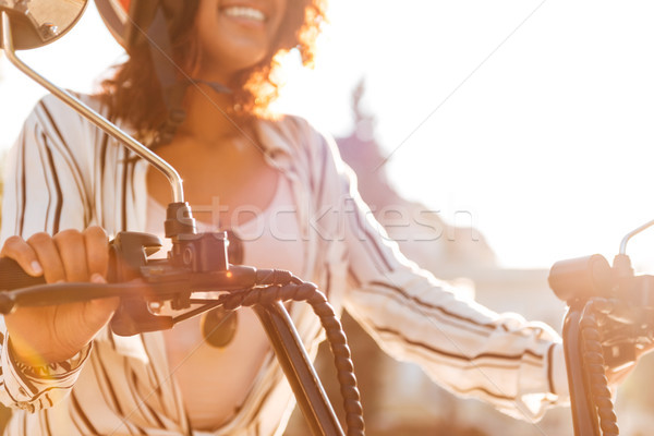 Cropped image of happy african woman sitting on modern motorbike Stock photo © deandrobot