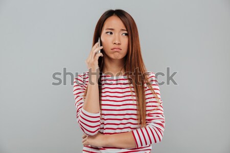 Portrait of a sad asian woman standing with arms folded Stock photo © deandrobot