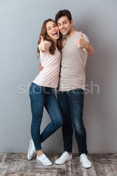 Full length portrait of a happy cheerful couple hugging Stock photo © deandrobot