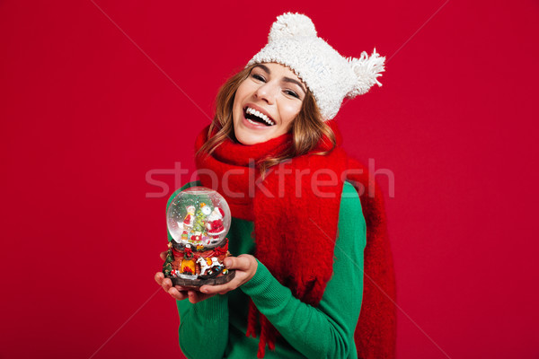 Young pretty lady wearing hat and scarf holding christmas toy Stock photo © deandrobot