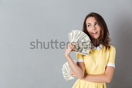 Contented nice woman rejoicing her purchases holding fan of 100  Stock photo © deandrobot