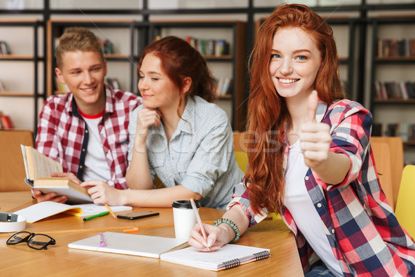 Grup zâmbitor adolescenti teme pentru acasa şedinţei bibliotecă Imagine de stoc © deandrobot