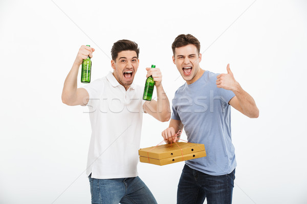 Portrait of two happy young men celebrating Stock photo © deandrobot