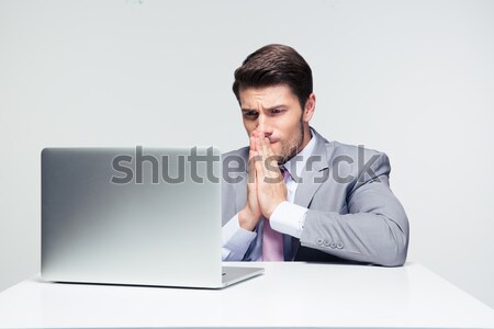 Businessman sitting at the table and praying  Stock photo © deandrobot