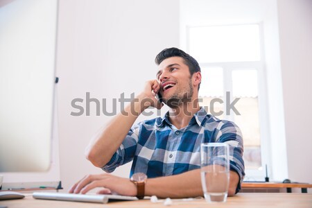 Young businessman speaking on the phone in office Stock photo © deandrobot