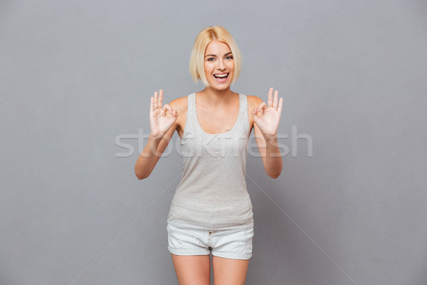 Stock photo: Smiling beautiful young woman showing ok sign with both hands