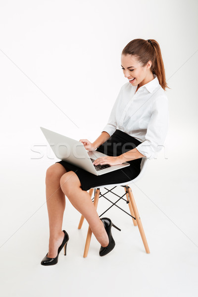 Ritratto imprenditrice utilizzando il computer portatile sedia da ufficio sorridere isolato Foto d'archivio © deandrobot