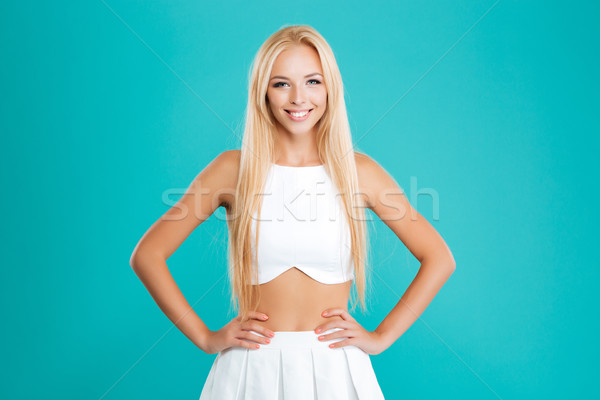 Portrait of a lovely woman standing with hands on hips Stock photo © deandrobot