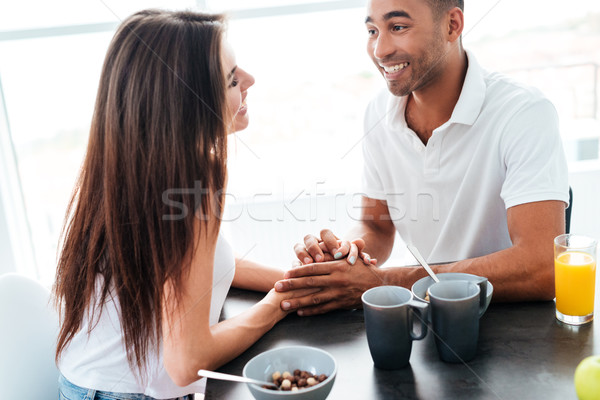 Couple holding hands and having breakfast on the kitchen Stock photo © deandrobot