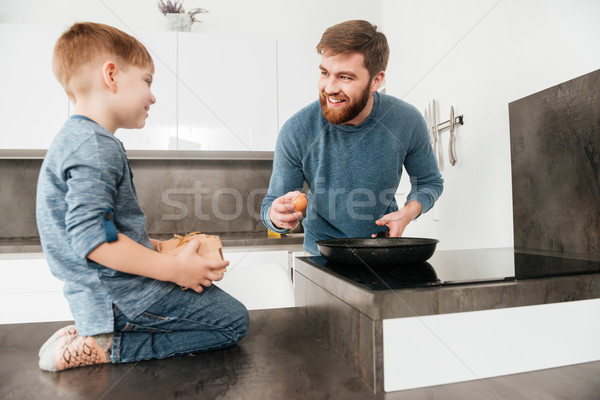 Happy bearded father cooking at kitchen with his little son Stock photo © deandrobot