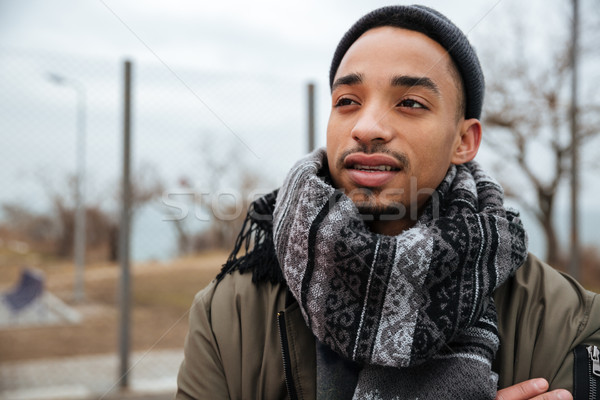 Portrait of african american young man standing outdoors in autumn Stock photo © deandrobot