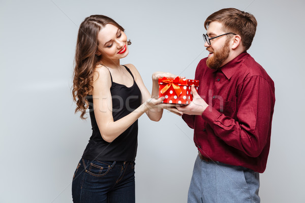 Stock photo: Smiling Male nerd presents the gift for Pleased Woman