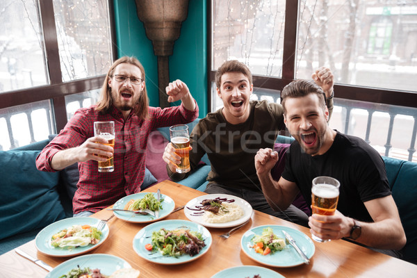 Alegre hombres amigos sesión Servicio potable Foto stock © deandrobot