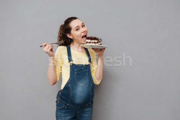 Retrato animado jovem mulher grávida alimentação bolo de chocolate Foto stock © deandrobot