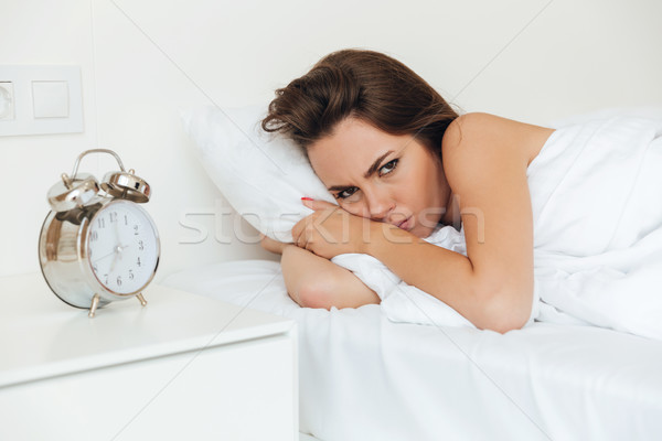 Angry pretty woman laying in bed in the morning Stock photo © deandrobot