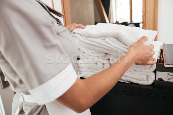 Hotel maid taking fresh towels from a housekeeping cart Stock photo © deandrobot
