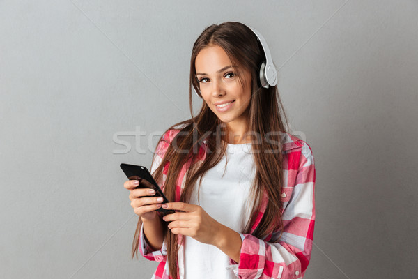 Young smiling beautiful brunette woman with long hair, listening Stock photo © deandrobot