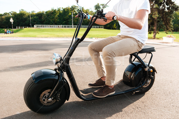 Cropped side view of young man rides on modern motorbike Stock photo © deandrobot