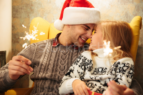 Photo of happy father in Santa's hat touchig with noses his litt Stock photo © deandrobot