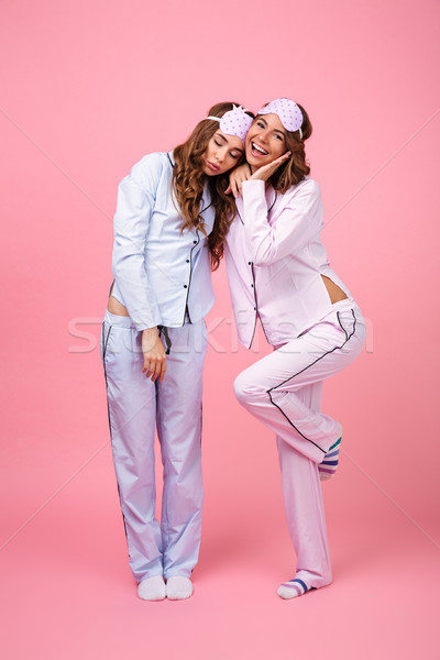 Stock photo: Woman in pajama looking camera while her friend sleeping