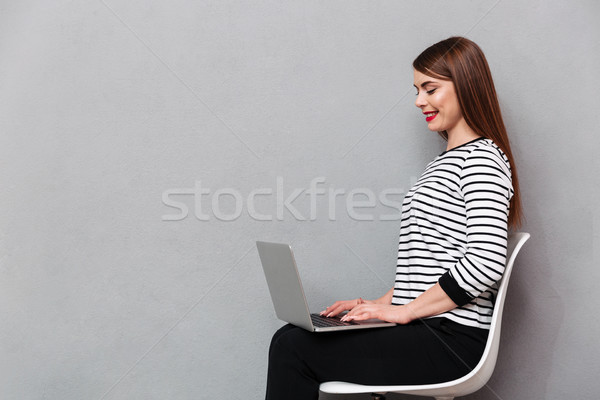 Portrait of a happy woman sitting on chair Stock photo © deandrobot