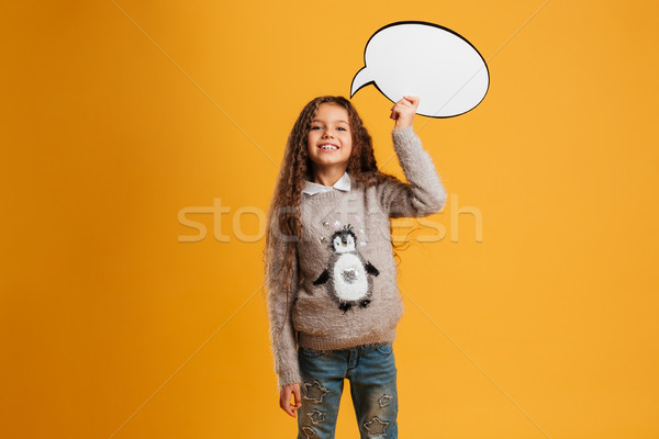 Cheerful little girl child holding speech bubble. Looking camera. Stock photo © deandrobot