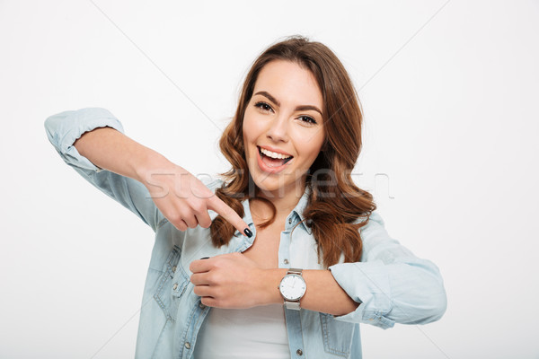 Cheerful young woman showing her watch on the hand. Stock photo © deandrobot