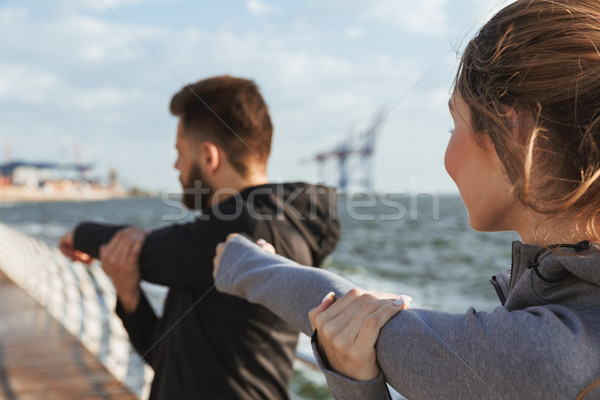 Healthy young sports couple doing stretching exercises Stock photo © deandrobot