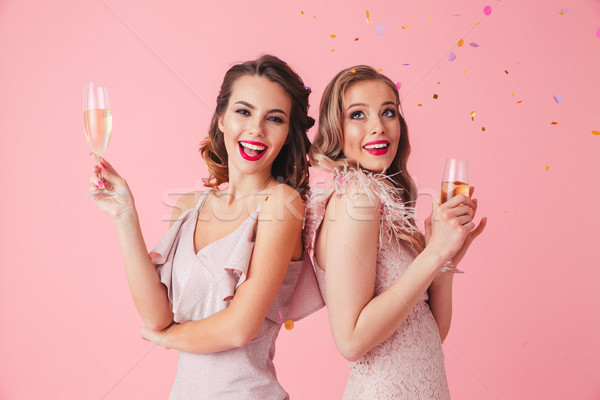 Two happy elegant women in dresses posing together with champagne Stock photo © deandrobot