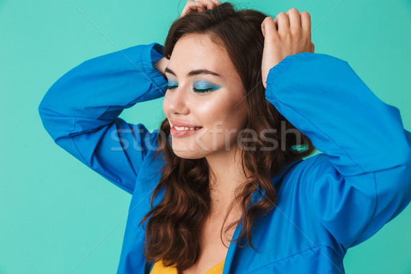 Photo of beautiful brunette woman 20s wearing raincoat or jacket Stock photo © deandrobot
