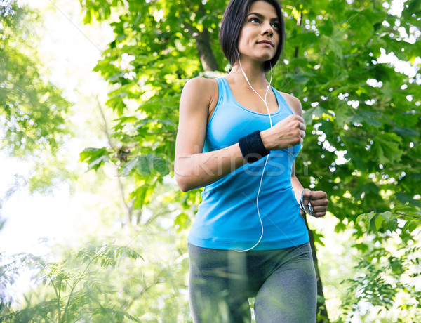 Beautiful sporty woman running in the park Stock photo © deandrobot
